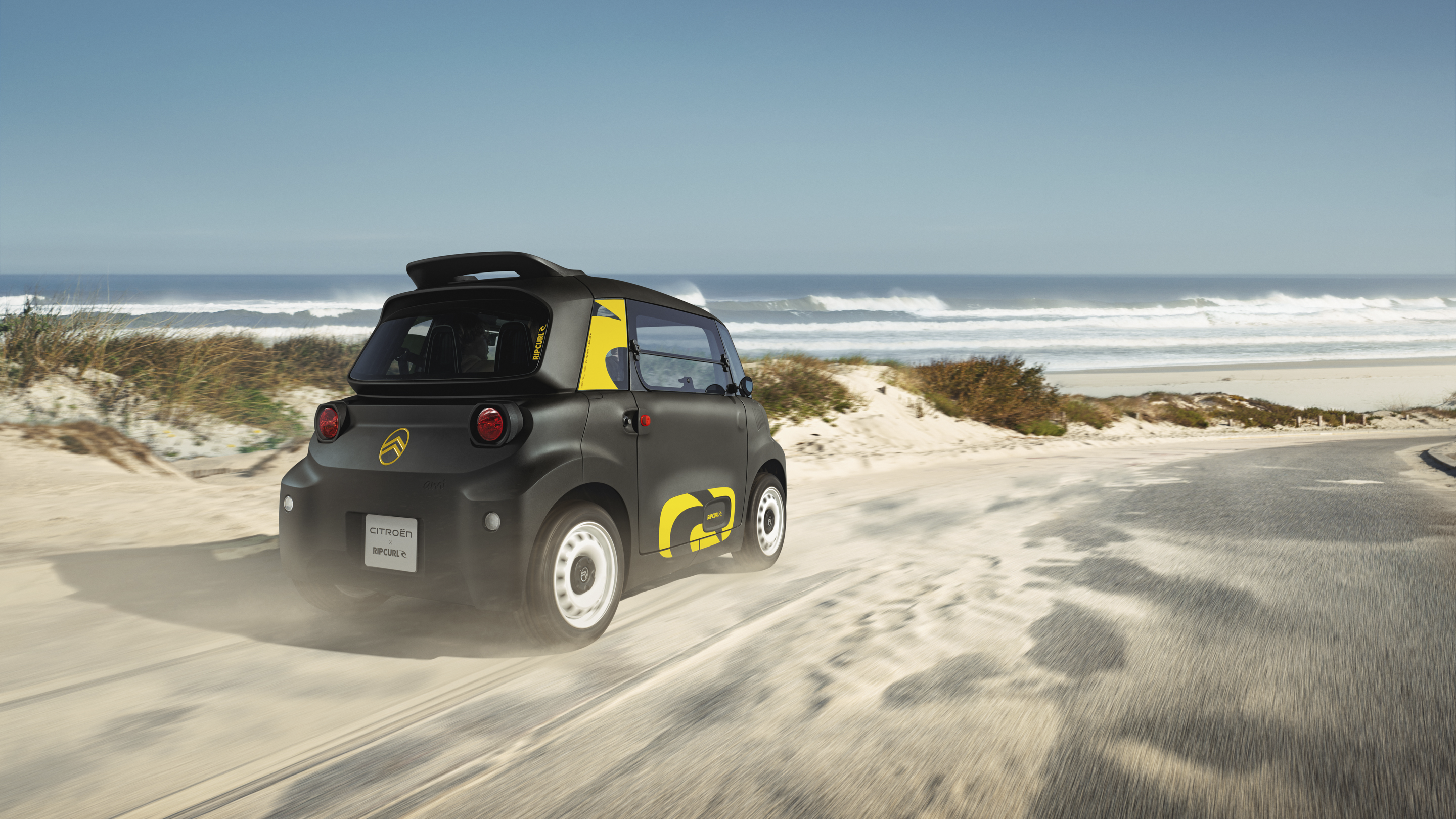 Dynamische Dreiviertelansicht von hinten Citroën Ami x Rip Curl Elektrofahrzeug ohne Führerschein, Citroën Ami Freiheit für urbane Elektromobilität