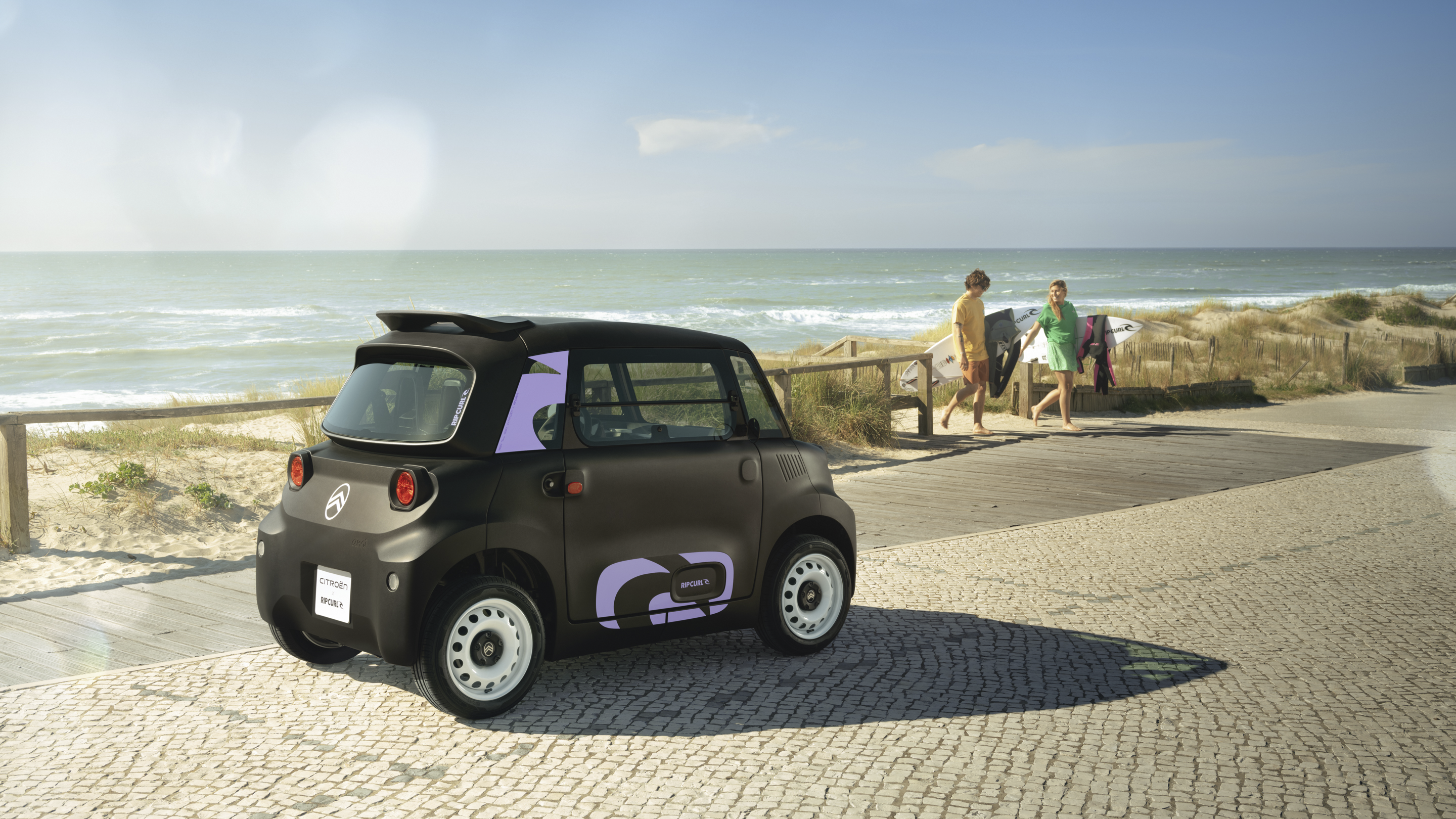 Dreiviertelansicht von hinten Citroën Ami x Rip Curl Elektrofahrzeug ohne Führerschein, Citroën Ami Küstenfreiheit für urbane Elektromobilität
