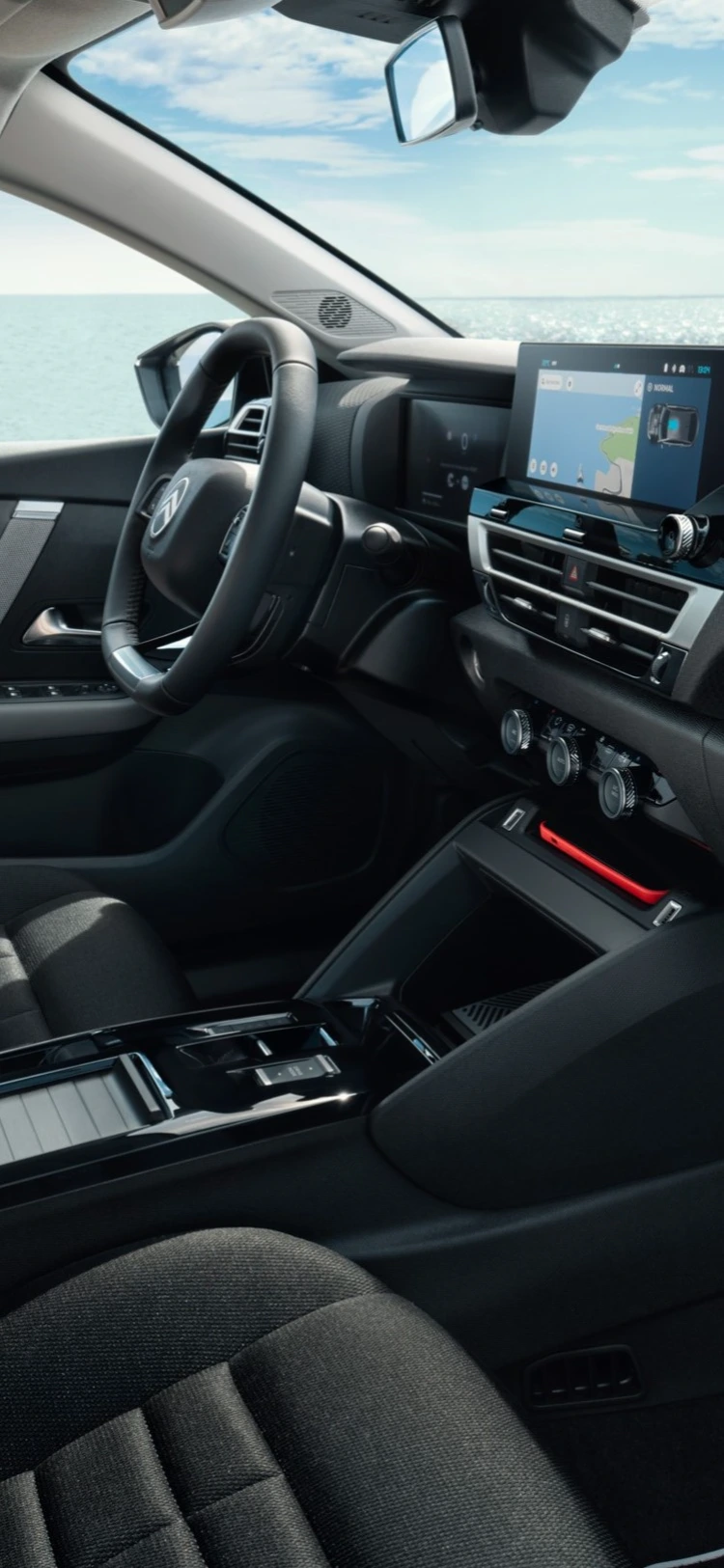Vordere Kabine des Citroën C4 X mit Armaturenbrett und Sitzen vor Meereskulisse