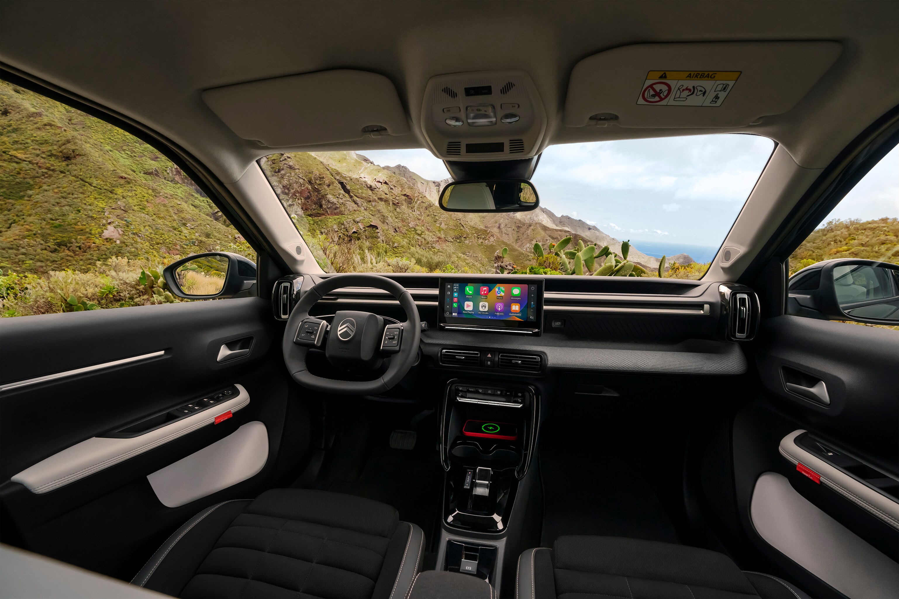Innenraum-Frontansicht des Citroën ë-C3 Aircross SUV präsentiert Panorama-Armaturenbrett und großen Touchscreen für intuitives, geräumiges und erschwingliches Alltagsfahren.